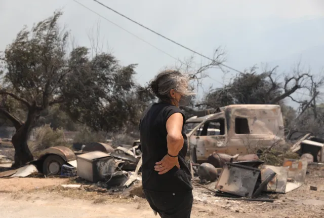 Γυναίκα κοιτάζει τις καταστροφές από τη φωτιά στο Πόρτο Γερμενό