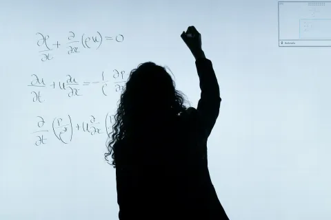 Εκπαιδευτικός γυναίκα γράφει σε ψηφιακό πίνακα και φαίνεται μόνο το περίγραμμα της σκιάς της