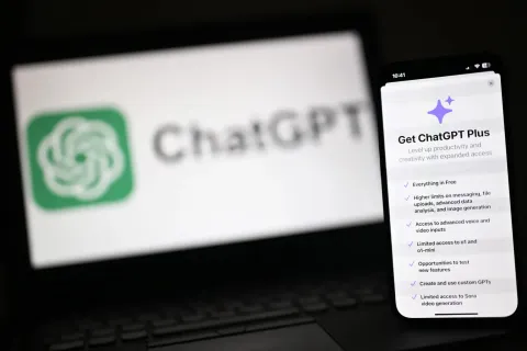 Υπολογιστής και κινητό που δείχνουν το λογότυπο του ChatGPT