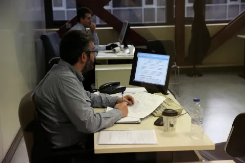 Προιστάμενος εργαζόμενοι δημόσιος υπάλληλος στο Δημόσιο κοιτάζει υπολογιστή