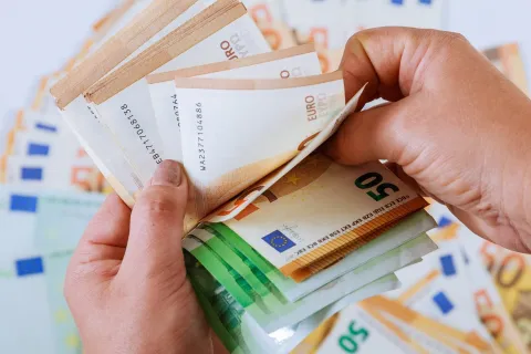 Ανδρικά χέρια μετράνε το εφάπαξ σε χρήματα