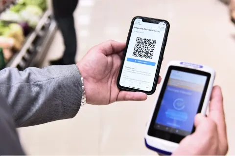 Ανδρικά χέρια κρατάνε κινητό με barcode μέσα από την εφαρμογή του ΕΡΓΑΝΗ
