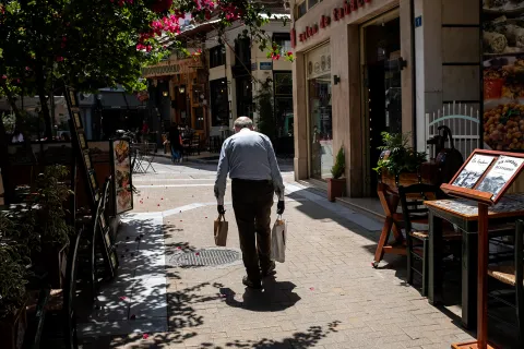 Συνταξιούχος περπατάει σε σοκάκι της Αθήνας