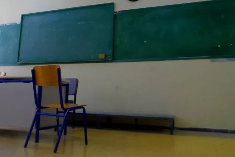 Άδεια αίθουσα τάξης μετά την απόλυση δασκάλας, φαίνεται καρέκλα, έδρα και πίνακας