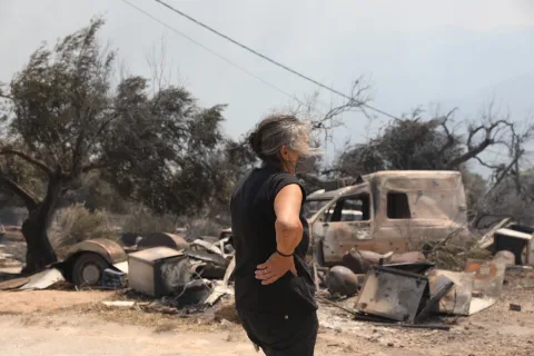 Γυναίκα κοιτάζει τις καταστροφές από τη φωτιά στο Πόρτο Γερμενό