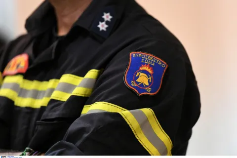 Πυροσβέστης όπου στο μανίκι του έχει λογότυπο της Πυροσβεστικής