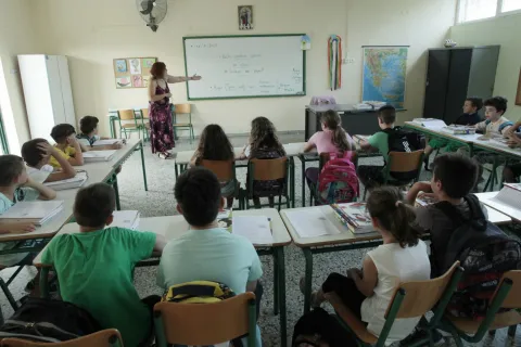 Γυναίκα εκπαιδευτικός παραθέτει μάθημα σε σχολική τάξη