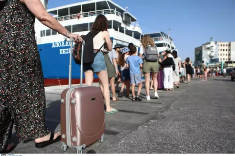 Γυναίκα με τη βαλίτσα στο χέρι ετοιμάζεται να μπει σε πλοίο