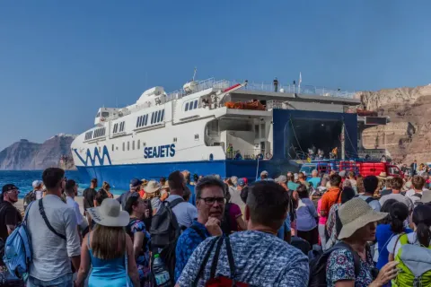Άνθρωποι σε λιμάνι περιμένουν την επιβίβαση σε πλοίο για διακοπές